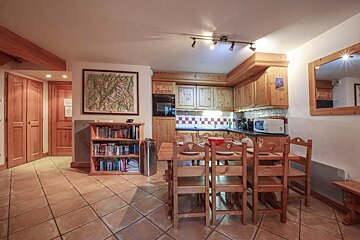 A kitchen with a table and chairs and a map on the wall