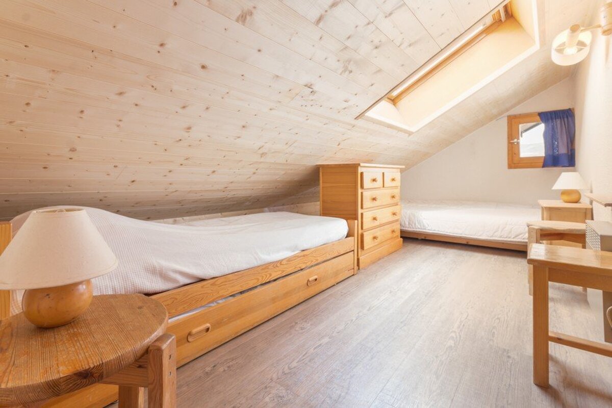 A bedroom with two beds and two lamps