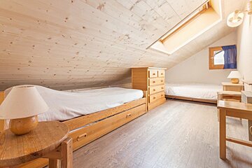 A bedroom with two beds and two lamps
