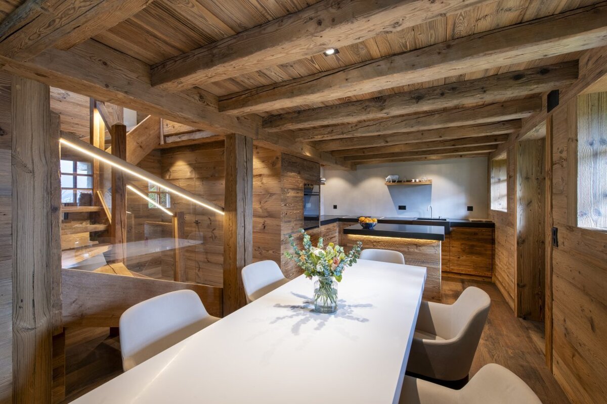A dining room table with a vase of flowers on it