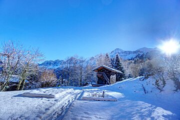A snowy landscape with mountains in the background