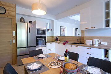 A bottle of wine sits on a table in a kitchen