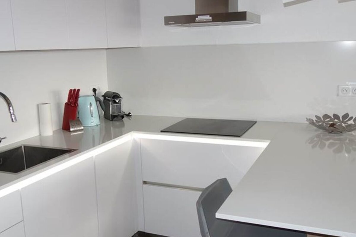 A kitchen with white cabinets and a stove top oven