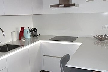 A kitchen with white cabinets and a stove top oven