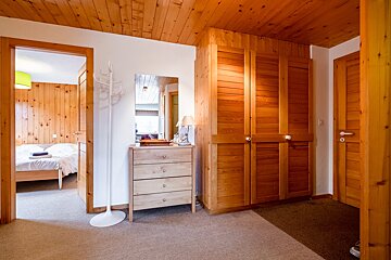 A wooden hallway with a dresser and a mirror