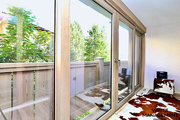 A room with sliding glass doors and a cow print rug