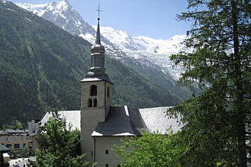A church in the mountains with a cross on top