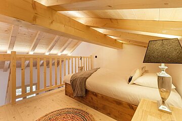 A bedroom with a wooden bed and a lamp