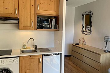 A kitchen with a sink and a washer and dryer