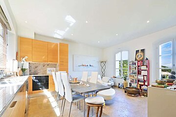 A kitchen with a table and chairs and a painting on the wall