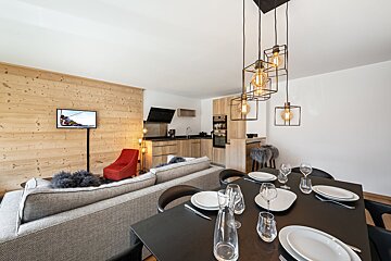 A living room with a dining table and a television