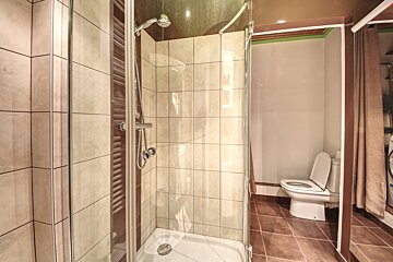 A bathroom with a walk in shower and a toilet
