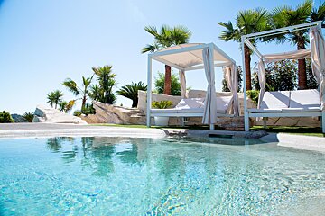 A canopy bed sits next to a swimming pool