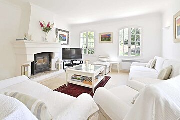 A living room with white furniture and a fireplace