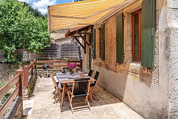 A patio with a table and chairs under an awning