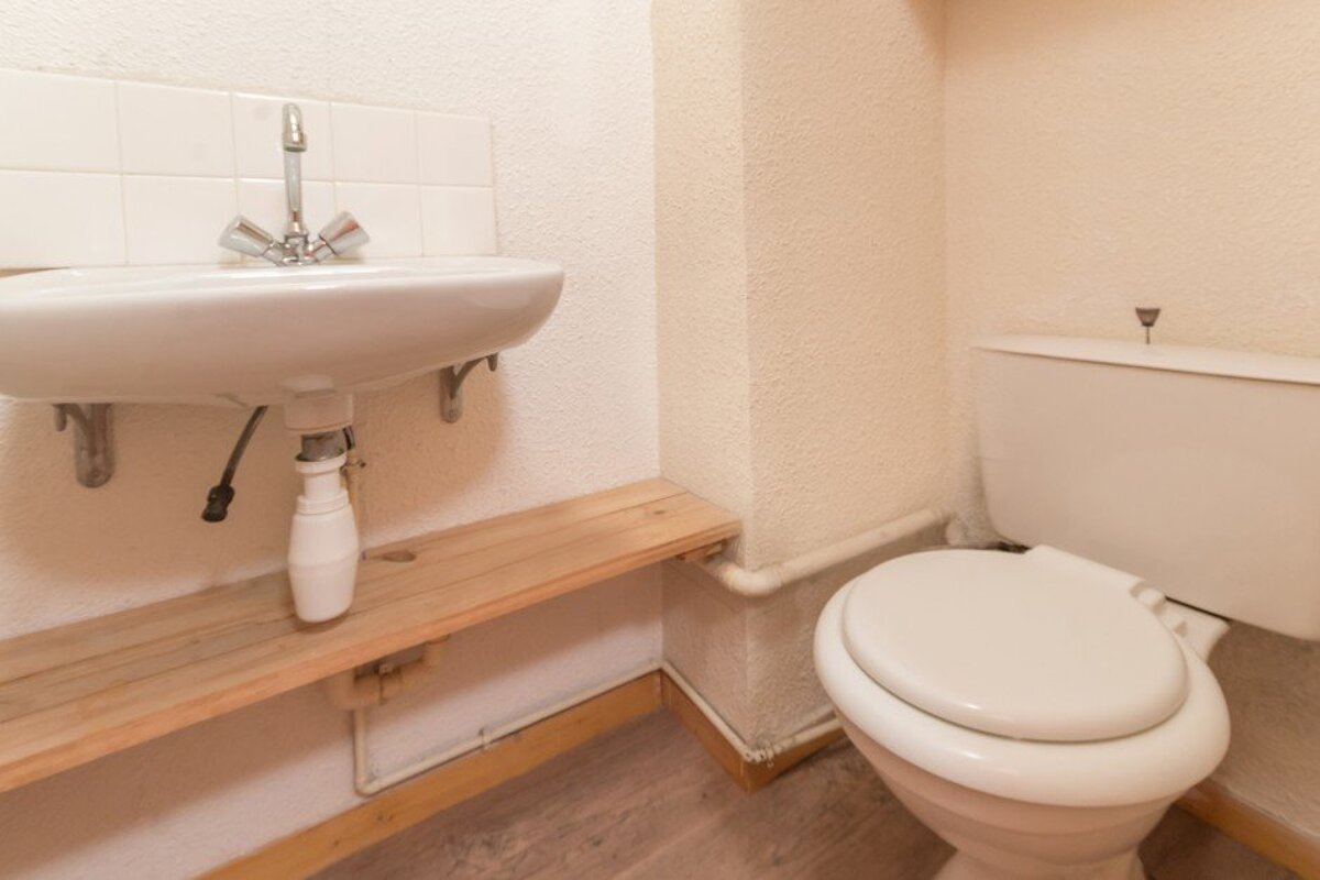 A toilet sits next to a sink in a bathroom