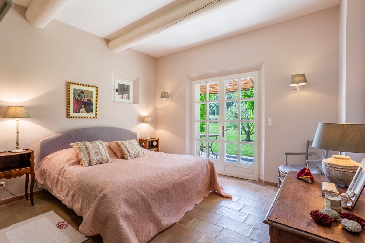 A bedroom with a pink bed and a picture on the wall