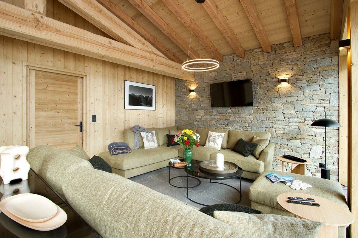 A living room with a large sectional couch and a flat screen tv