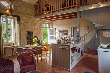 A kitchen and dining area with a sign on the wall that says 