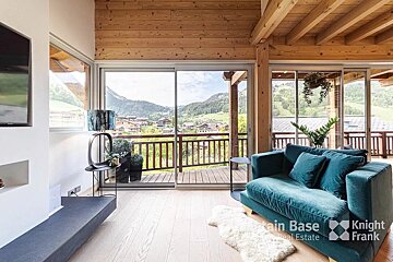 A living room with a blue couch and a knight frank logo
