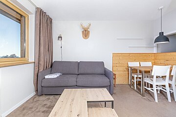 A living room with a couch and a table and chairs