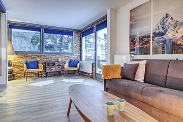 A living room with a couch and two cups on a coffee table