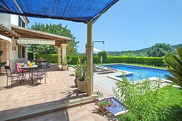 A patio with a table and chairs and a swimming pool