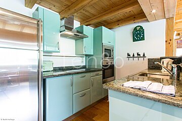 A kitchen with blue cabinets and a clock on the wall