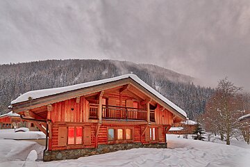A snowy cabin with a mountain in the background