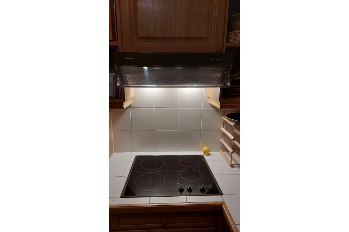 A stove top with a bosch hood above it