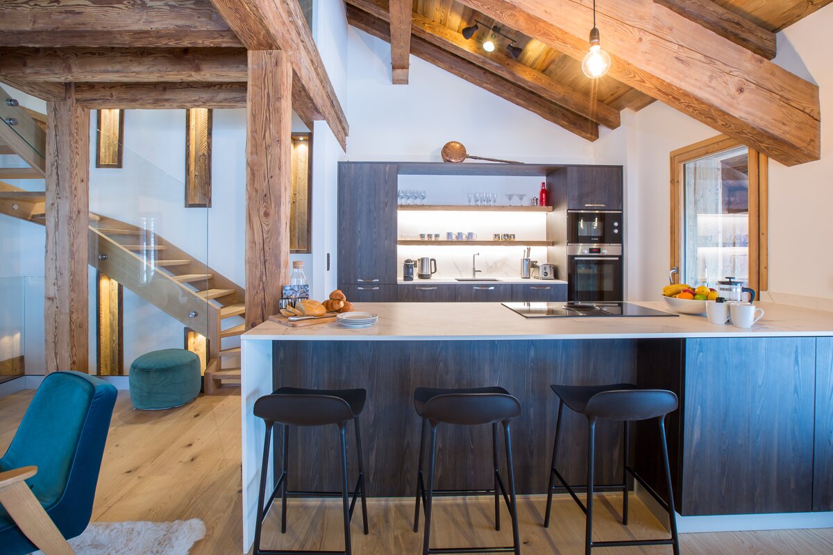 A kitchen with a staircase leading to the second floor