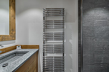 A bathroom with a sink and a towel rack