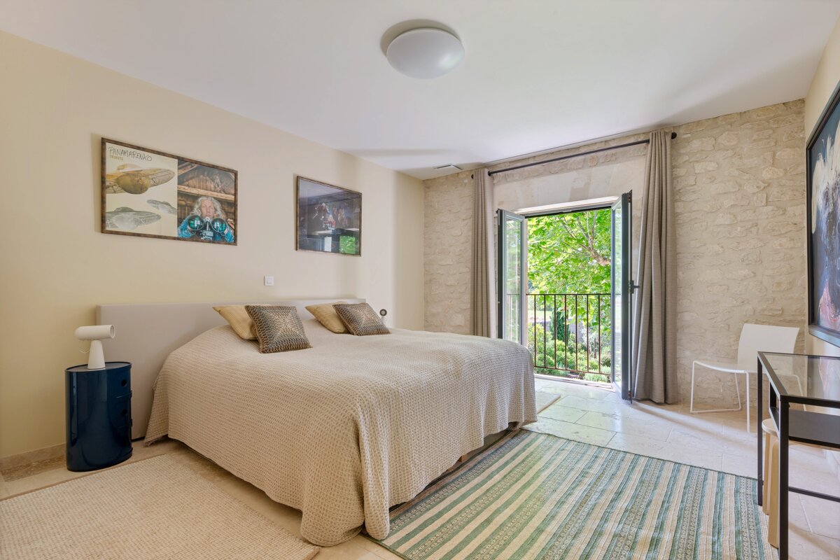 A bedroom with a large bed and a striped rug