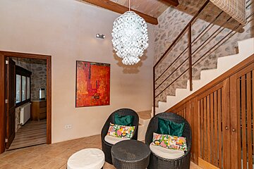 A room with two chairs and a table with a chandelier hanging from the ceiling