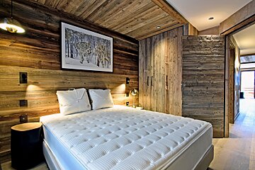 A bedroom with a picture of a wolf on the wall above the bed