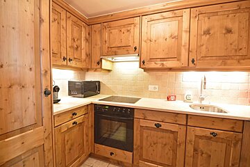 A kitchen with wooden cabinets and a stove top oven