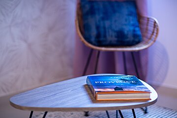 A book titled provence sits on a table next to a chair