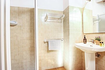 A bathroom with a sink a mirror and a shower