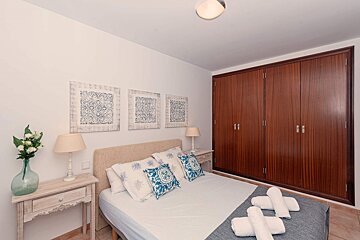 A bedroom with a large closet and a bed