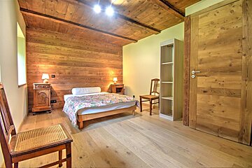 A bedroom with wooden walls and a bed