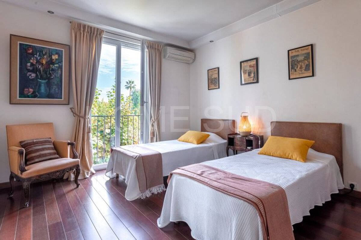 A bedroom with two beds and a chair and a sign that says me sud