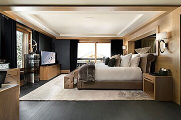 A bedroom with a large bed and a flat screen tv