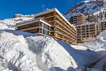 A snow covered building with a mountain in the background