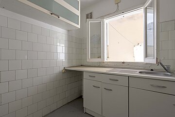 A kitchen with white cabinets a sink and a window