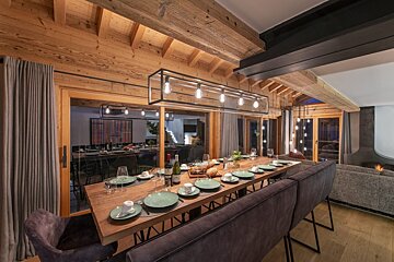 A dining room table with plates and a bottle of wine on it