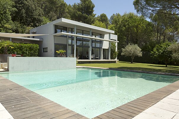 A house with a large swimming pool in front of it