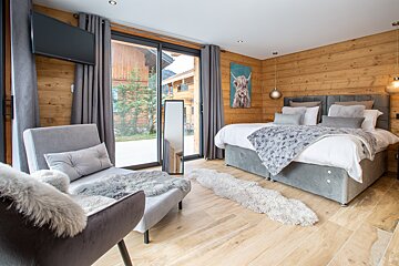 A bedroom with two beds a chair and a television