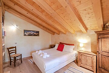 A bedroom with a picture on the wall above the bed