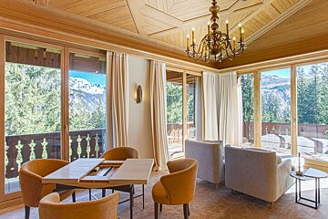 A room with a table and chairs and a chandelier
