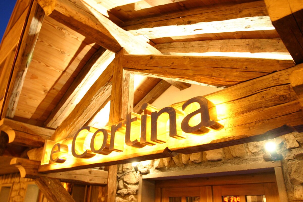 The word cortina that is on a wooden sign